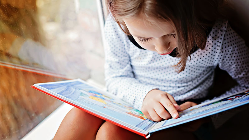 Small girl reading a book
